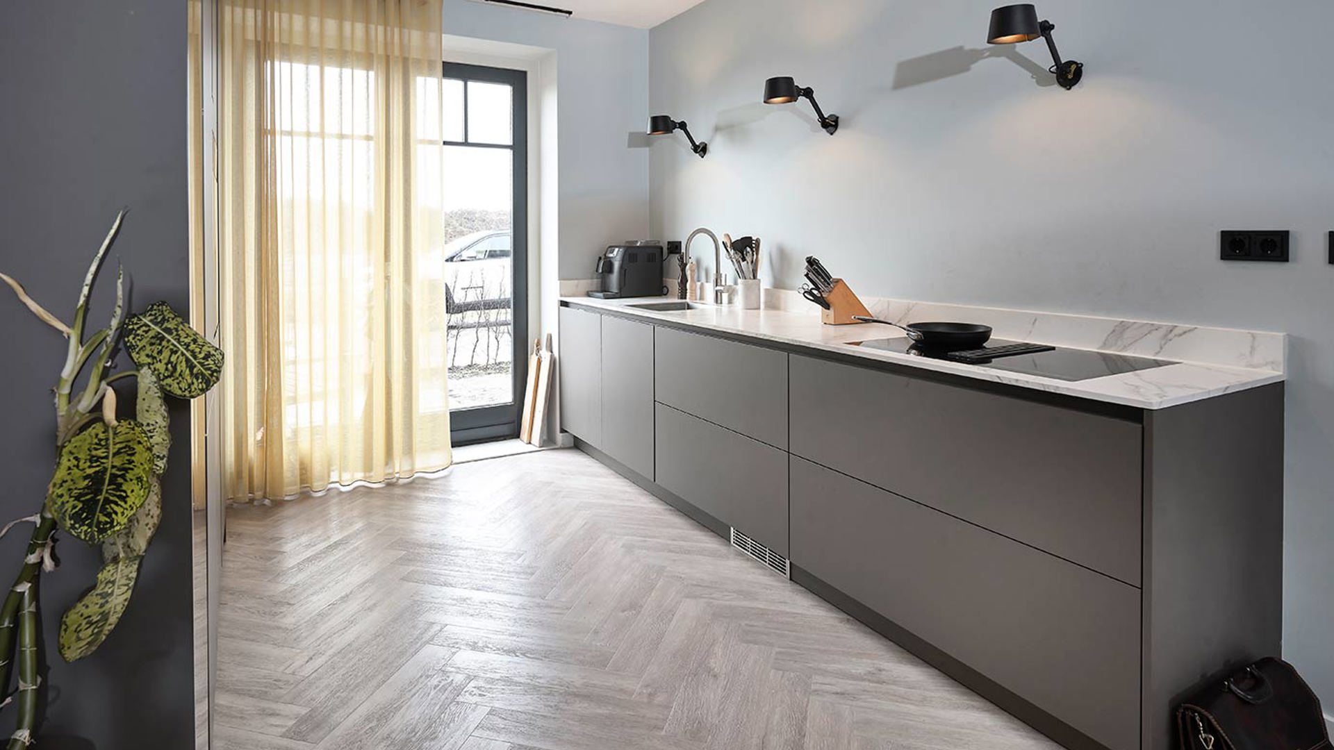 Zwarte moderne keuken met houten visgraat vloer